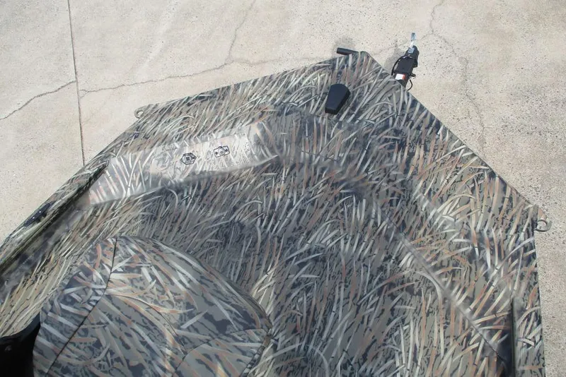 Slide: The Image of 2026 Tracker Grizzly 1654 T Sportsman boat with camouflage pattern on concrete surface. - 10