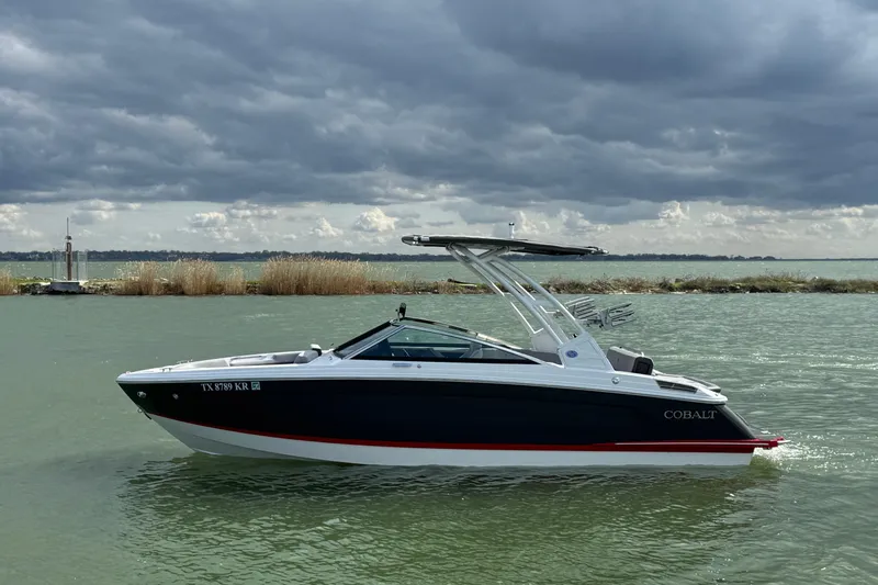 The Image of 2023 Cobalt R4 boat on a lake under cloudy skies. - 1