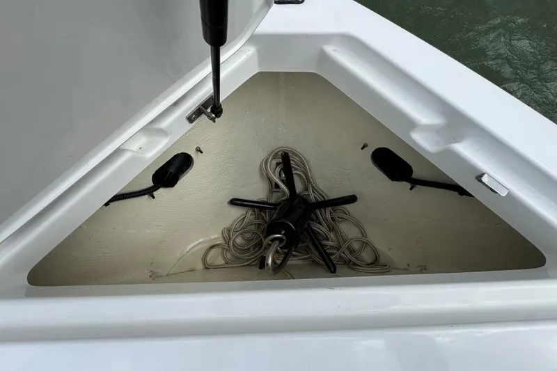 Slide: The Image of 2023 Cobalt R4 boat anchor storage compartment with coiled rope and anchor. - 12
