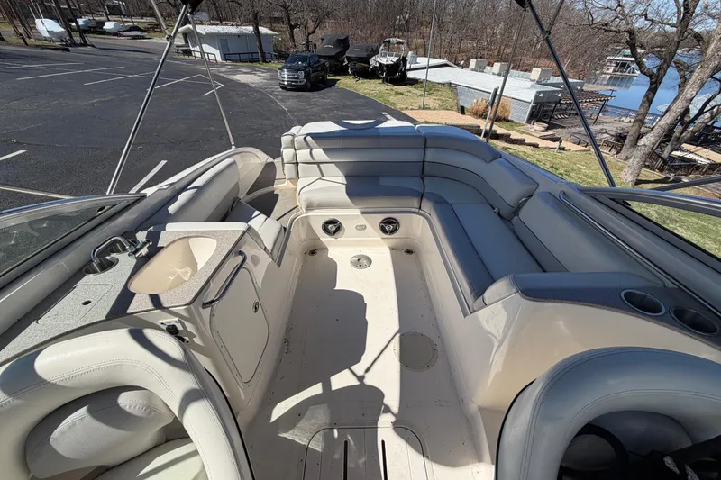 Slide: The Image of 2008 Bryant 268 boat interior with seating and sink, parked near a lake. - 12