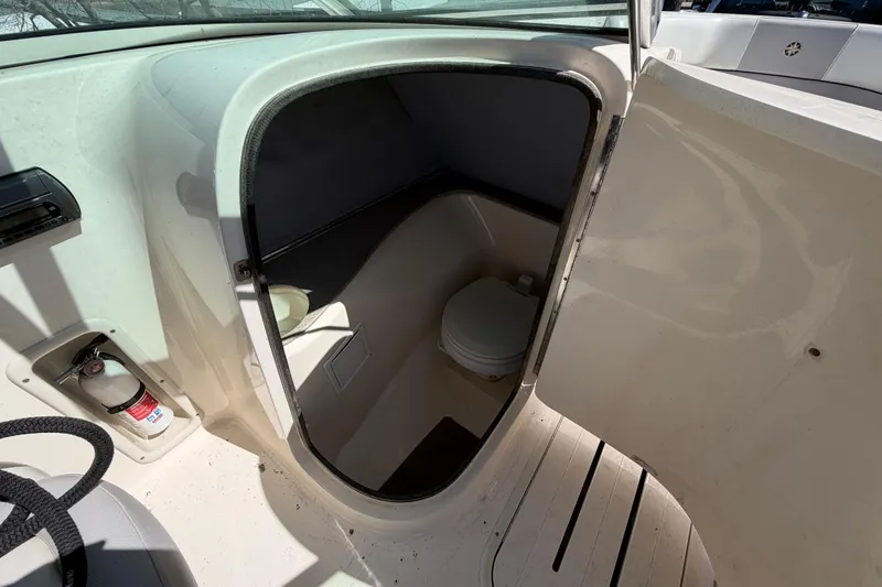 Slide: The Image of 2008 Bryant 268 boat interior with a compact marine toilet and fire extinguisher. - 13