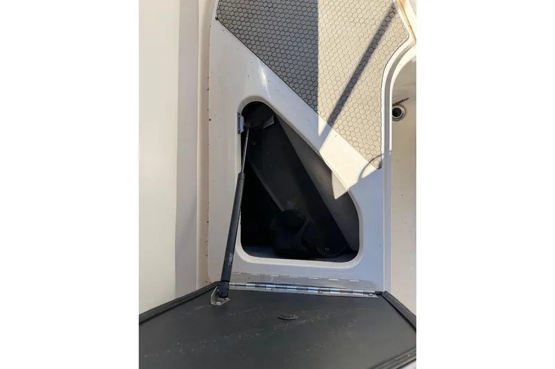 Slide: The Image of Storage compartment of a 2008 Bryant 268 boat with open hatch and hydraulic support. - 14