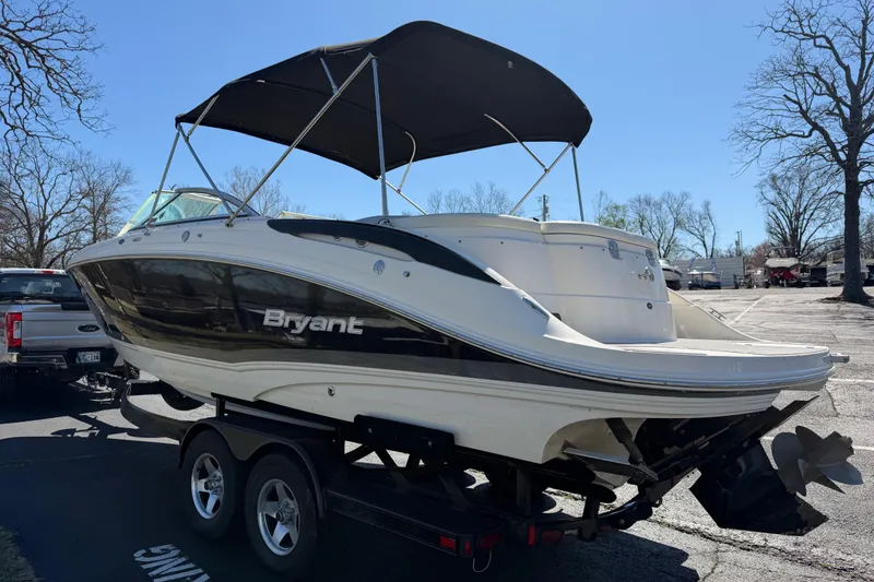 Slide: The Image of 2008 Bryant 268 boat on trailer with black canopy in parking lot. - 5