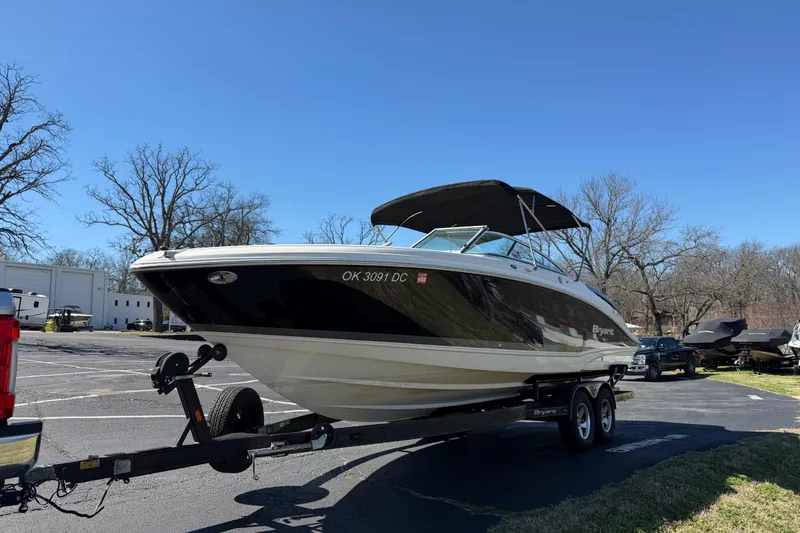 Slide: The Image of 2008 Bryant 268 boat on trailer in parking lot, clear blue sky background. - 7