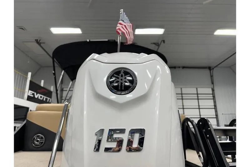 Slide: The Image of 2026 Evotti 521QL boat with 150 horsepower engine, displayed indoors with American flag. - 18