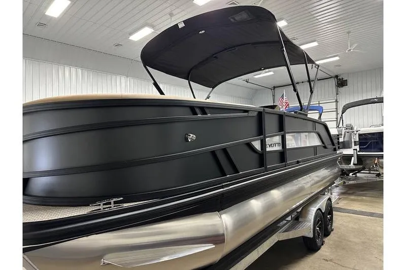Slide: The Image of 2026 Evotti 521QL pontoon boat in showroom, featuring sleek black design and canopy. - 20