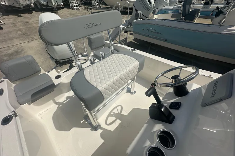 Slide: The Image of 2026 Pioneer 180 Sportfish boat interior with steering wheel and seating. - 10