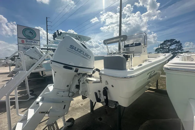 Slide: The Image of 2026 Pioneer 180 Sportfish boat with Suzuki outboard motor in dealership lot. - 5