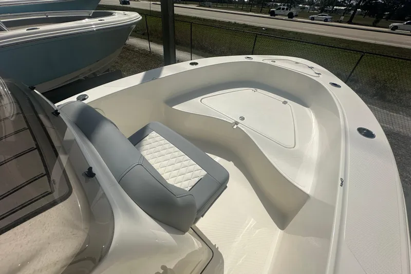 Slide: The Image of 2026 Pioneer 180 Sportfish boat interior with cushioned seating and storage compartments. - 7