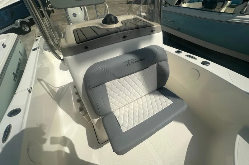 Slide: The Image of 2026 Pioneer 180 Sportfish boat interior with cushioned seating and console. - 9