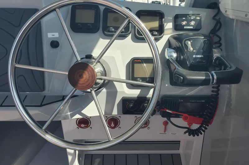 Slide: The Image of 1989 Boston Whaler Challenger boat dashboard with steering wheel and Yamaha controls. - 10