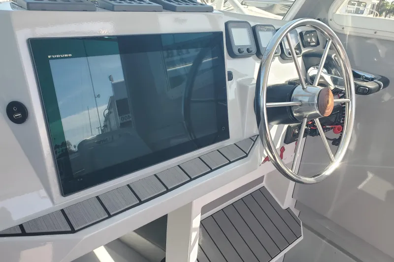Slide: The Image of 1989 Boston Whaler Challenger helm with modern navigation equipment and steering wheel. - 11