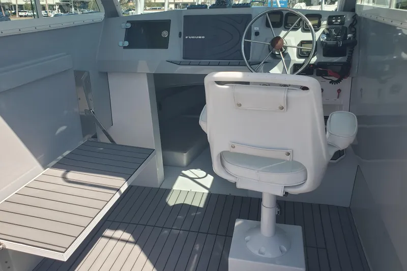 Slide: The Image of 1989 Boston Whaler Challenger boat interior with steering wheel and captain's chair. - 13
