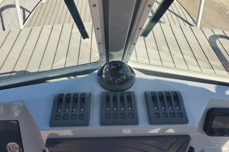Slide: The Image of 1989 Boston Whaler Challenger dashboard with compass and control switches. - 14