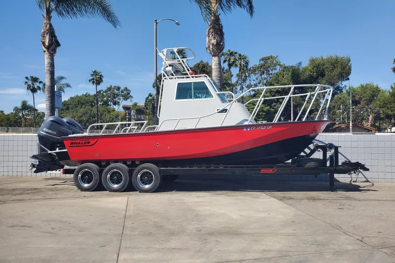 Slide: The Image of 1989 Boston Whaler Challenger boat on trailer, red and black, parked outdoors. - 2