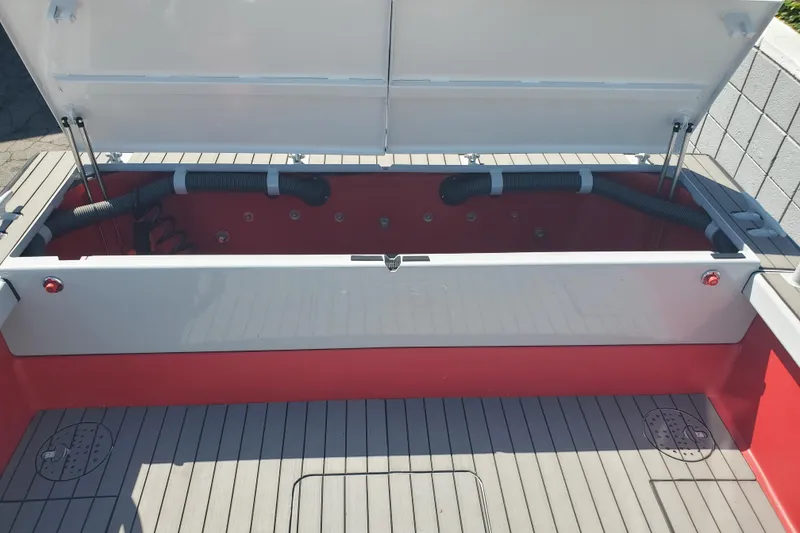 Slide: The Image of 1989 Boston Whaler Challenger boat interior with open storage compartment and visible hoses. - 23