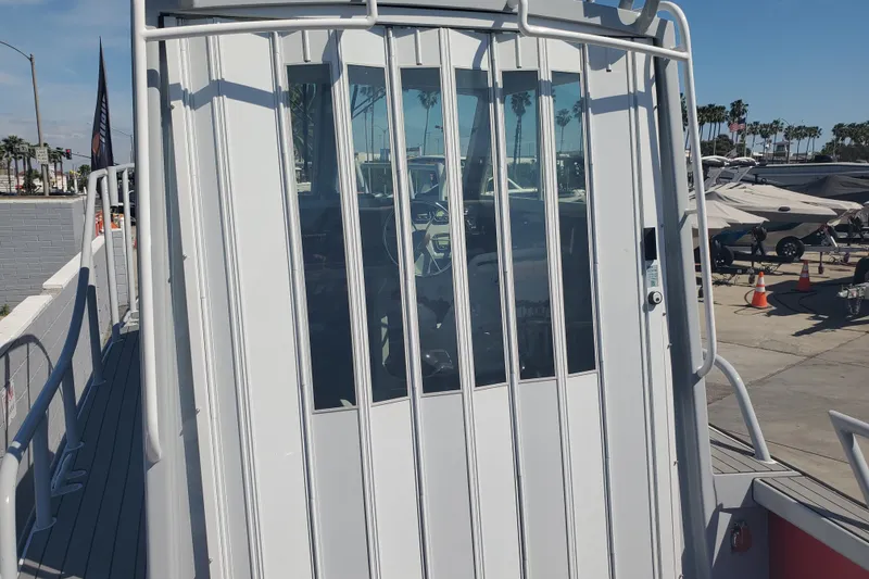 Slide: The Image of 1989 Boston Whaler Challenger boat with enclosed cabin, docked at a marina. - 24