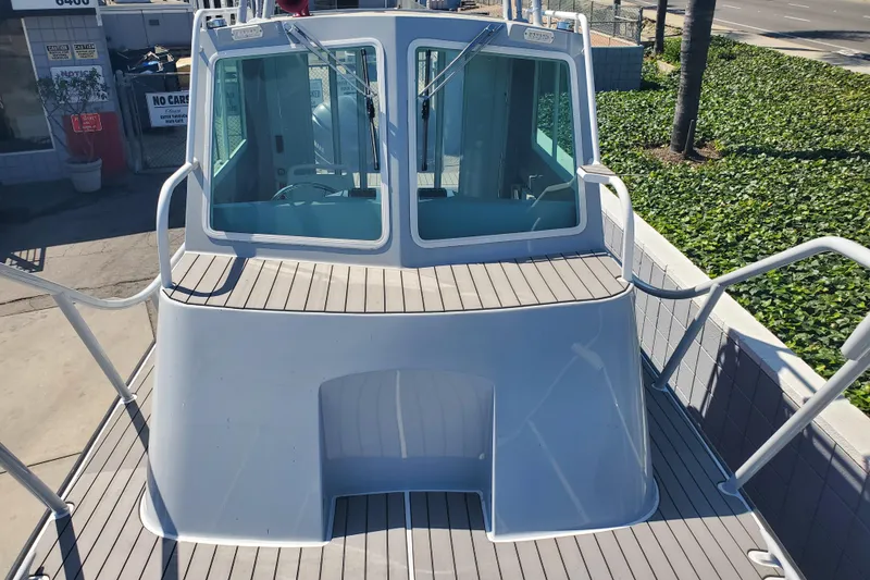 Slide: The Image of 1989 Boston Whaler Challenger boat deck with cabin view, docked outdoors. - 25