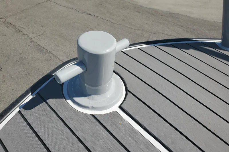 Slide: The Image of Boston Whaler Challenger 1989 boat deck with cleat, featuring gray planks and white trim. - 27