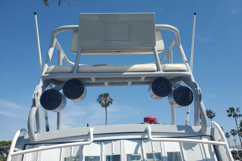 Slide: The Image of 1989 Boston Whaler Challenger boat with tower speakers, clear sky, and palm trees. - 28