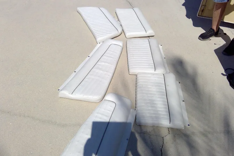 Slide: The Image of White boat cushions from a 2007 Tidewater 216 CC Adventure, arranged on concrete. - 16