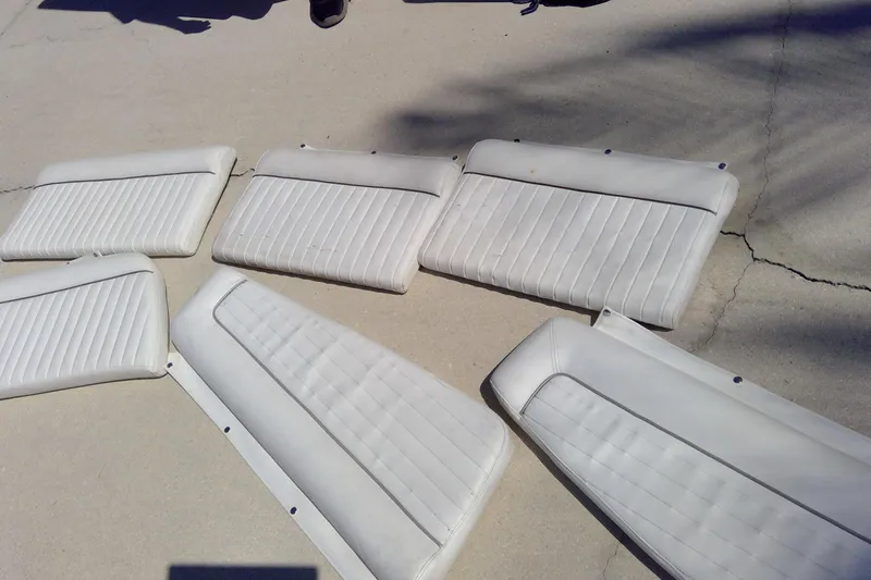 Slide: The Image of White boat cushions from a 2007 Tidewater 216 CC Adventure, displayed on concrete. - 17