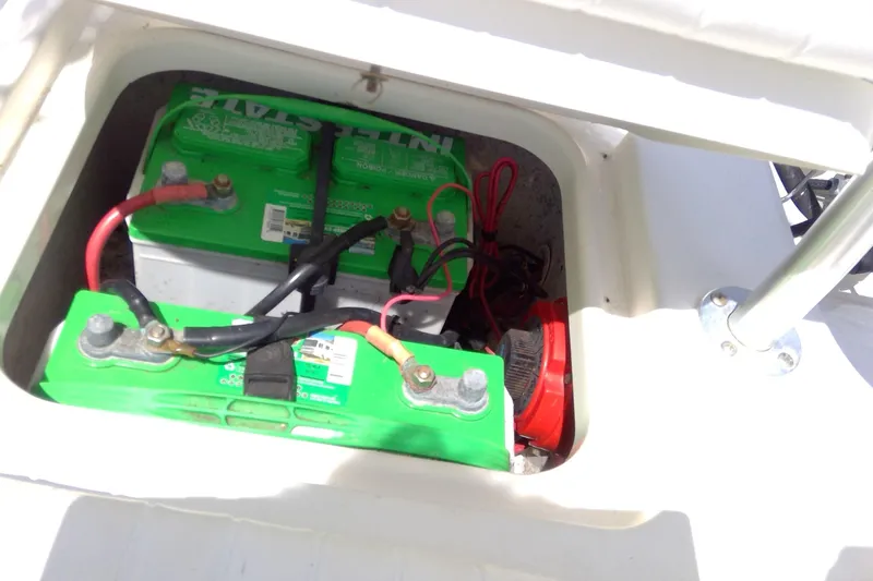 Slide: The Image of Battery compartment of 2007 Tidewater 216 CC Adventure boat, featuring dual green batteries. - 27