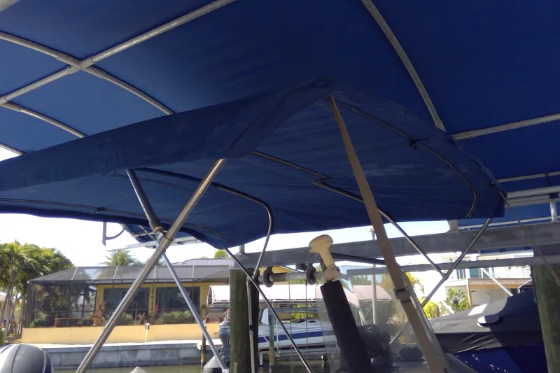 Slide: The Image of Blue canopy on a 2007 Tidewater 216 CC Adventure boat docked near waterfront homes. - 5