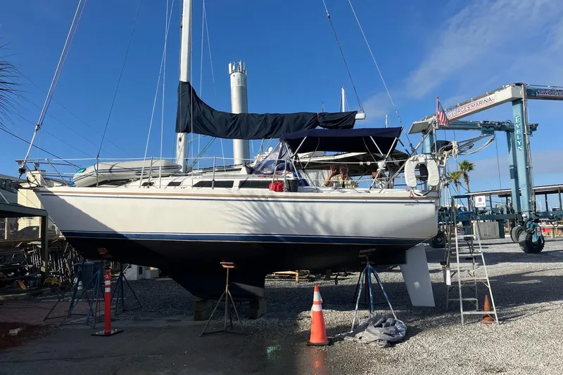 Slide: The Image of 1988 Catalina 30 MkIII sailboat on dry dock at marina, under clear blue sky. - 1