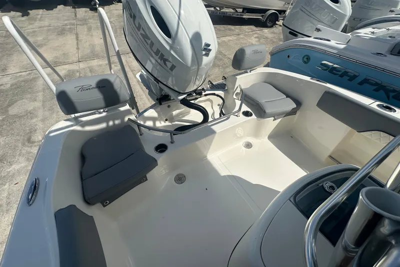 Slide: The Image of 2026 Pioneer 202 Sportfish boat interior with Suzuki engine, featuring seating and storage. - 10