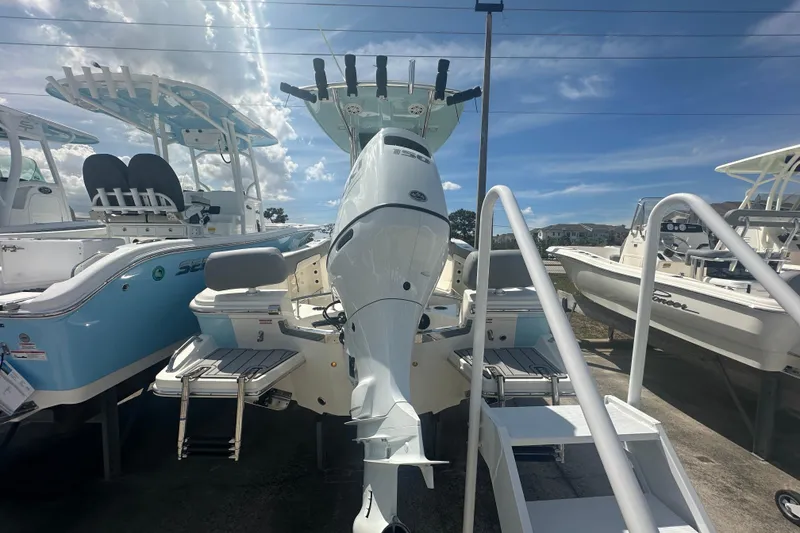 Slide: The Image of 2026 Pioneer 202 Sportfish boat displayed in a showroom under a clear blue sky. - 4
