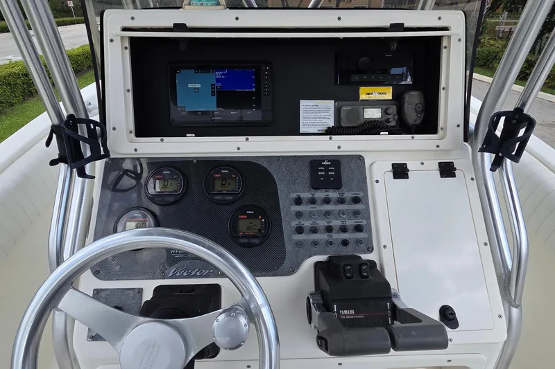 Slide: The Image of 2004 Hydra-Sports Vector 2400 CC boat dashboard with steering wheel and navigation controls. - 5