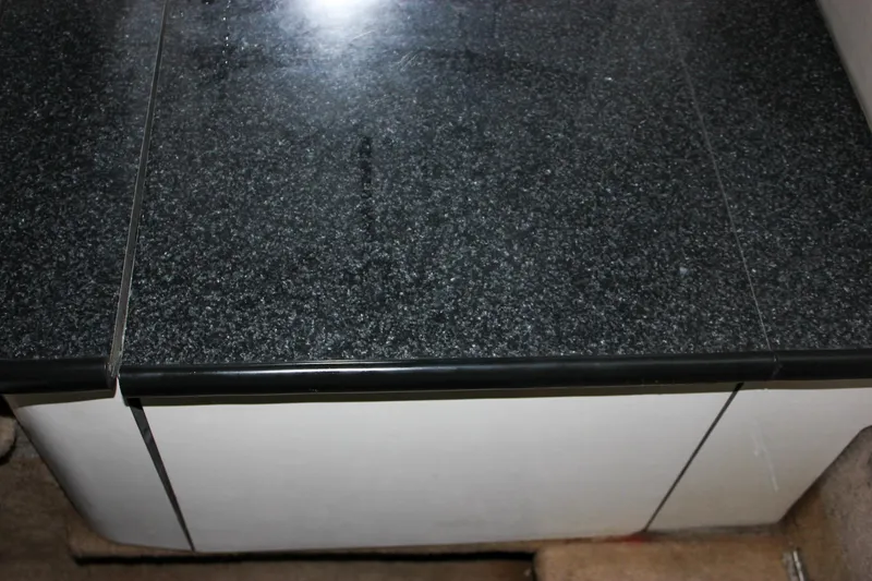 Slide: The Image of Black countertop on a 2000 Chaparral 245 SSi boat interior. - 8