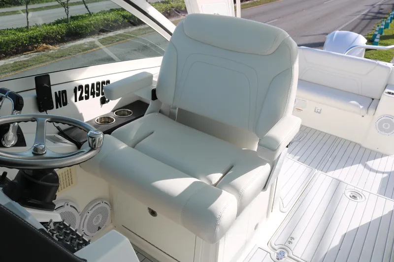 Slide: The Image of Captain's seat and helm of 2019 World Cat 320 DC boat, featuring sleek design and controls. - 11