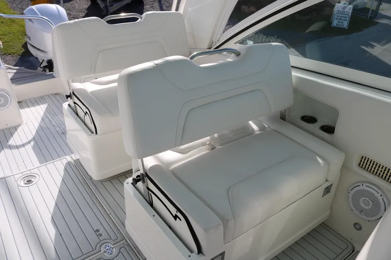 Slide: The Image of 2019 World Cat 320 DC boat interior with white seating and cup holders. - 12