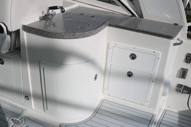 Slide: The Image of 2019 World Cat 320 DC boat interior with countertop and storage compartments. - 13
