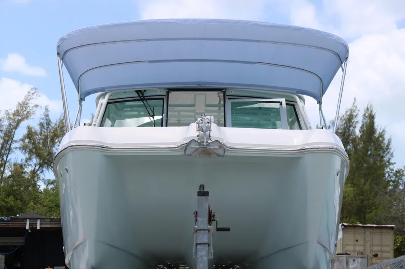 Slide: The Image of 2019 World Cat 320 DC boat with canopy, front view, outdoors. - 17