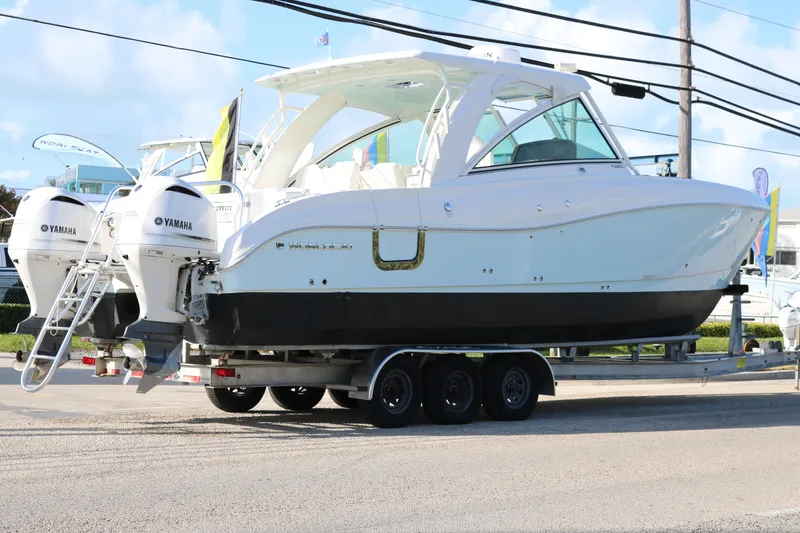 Slide: The Image of 2019 World Cat 320 DC boat on trailer with Yamaha engines, parked outdoors. - 4