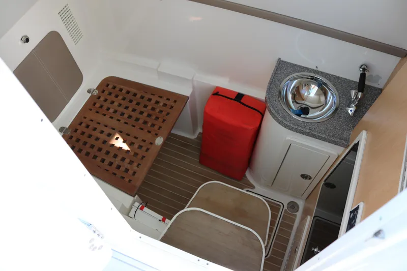 Slide: The Image of 2019 World Cat 320 DC interior with sink, wooden flooring, and red storage bag. - 8