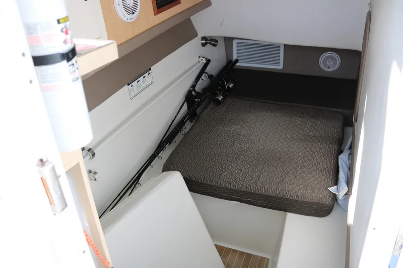 Slide: The Image of 2019 World Cat 320 DC cabin interior with fishing rods and cushioned seating. - 9
