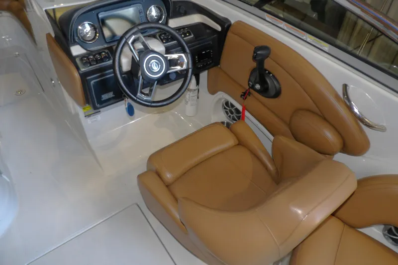 Slide: The Image of 2023 Crownline 250 XSS boat interior with tan leather seating and modern dashboard. - 10