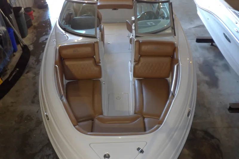 Slide: The Image of 2023 Crownline 250 XSS boat with brown leather seating in a garage setting. - 12