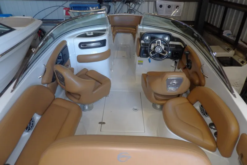 Slide: The Image of 2023 Crownline 250 XSS boat interior with tan seating and modern dashboard. - 3