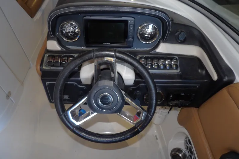Slide: The Image of 2023 Crownline 250 XSS boat dashboard with steering wheel and control panel. - 9