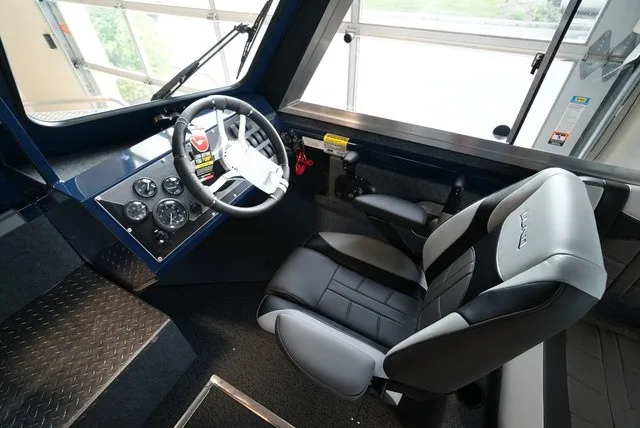 Slide: The Image of The image shows the cockpit of a Lund 185 Heavy Gauge Sport boat with a modern helm and comfortable seat. - 28