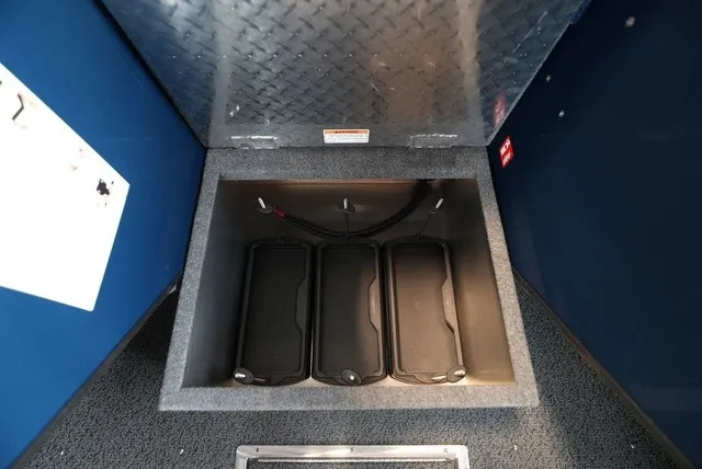 Slide: The Image of View of a storage compartment in the boat with three black batteries and blue wall paneling. - 36