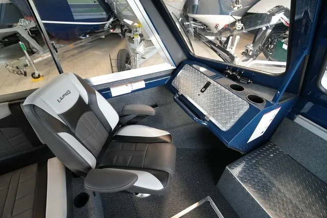 Slide: The Image of Interior of a Lund 185 Heavy Gauge Sport boat with cushioned seat and metal paneling. - 32
