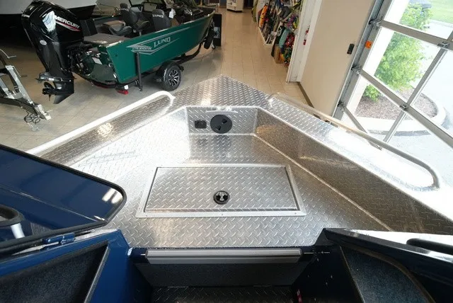 Slide: The Image of The image shows the bow deck of a Lund 185 Heavy Gauge Sport boat with aluminum diamond plating. - 37