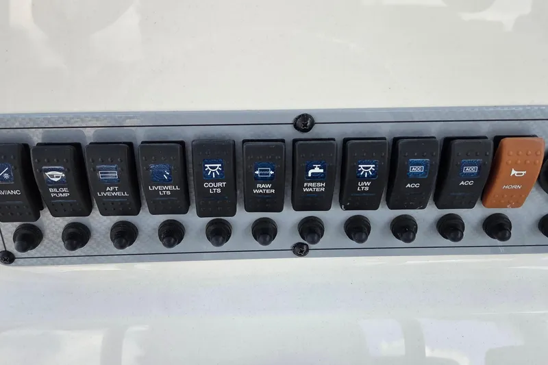 Slide: The Image of Control panel of a 2023 Key West 219 FS boat with labeled switches. - 16
