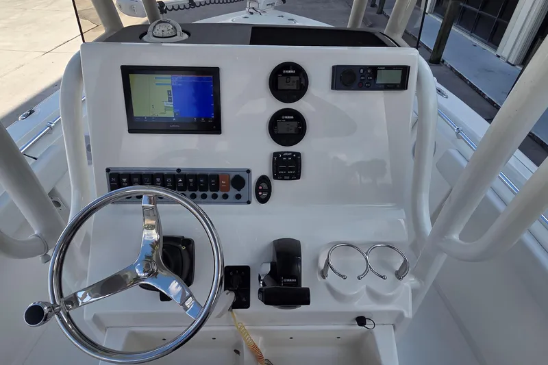 Slide: The Image of 2023 Key West 219 FS boat dashboard with steering wheel and electronic controls. - 19